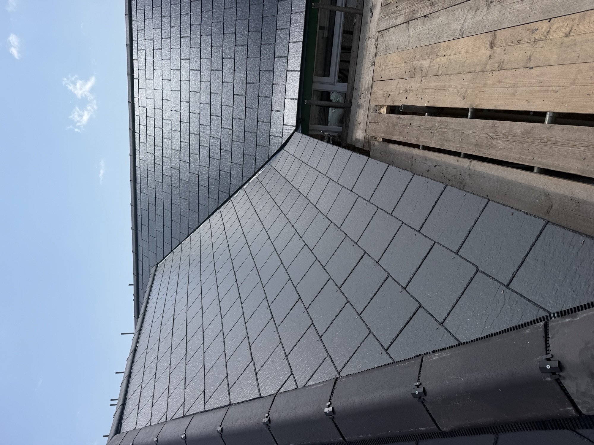 Dark slate roof slopes with ridge and valley detailing
